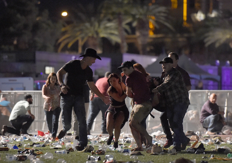 People carry a peson at the Route 91 Harvest country music festival after apparent gun fire was heard on October 1, 2017 in Las Vegas, Nevada. (Photo by David Becker/Getty Images)